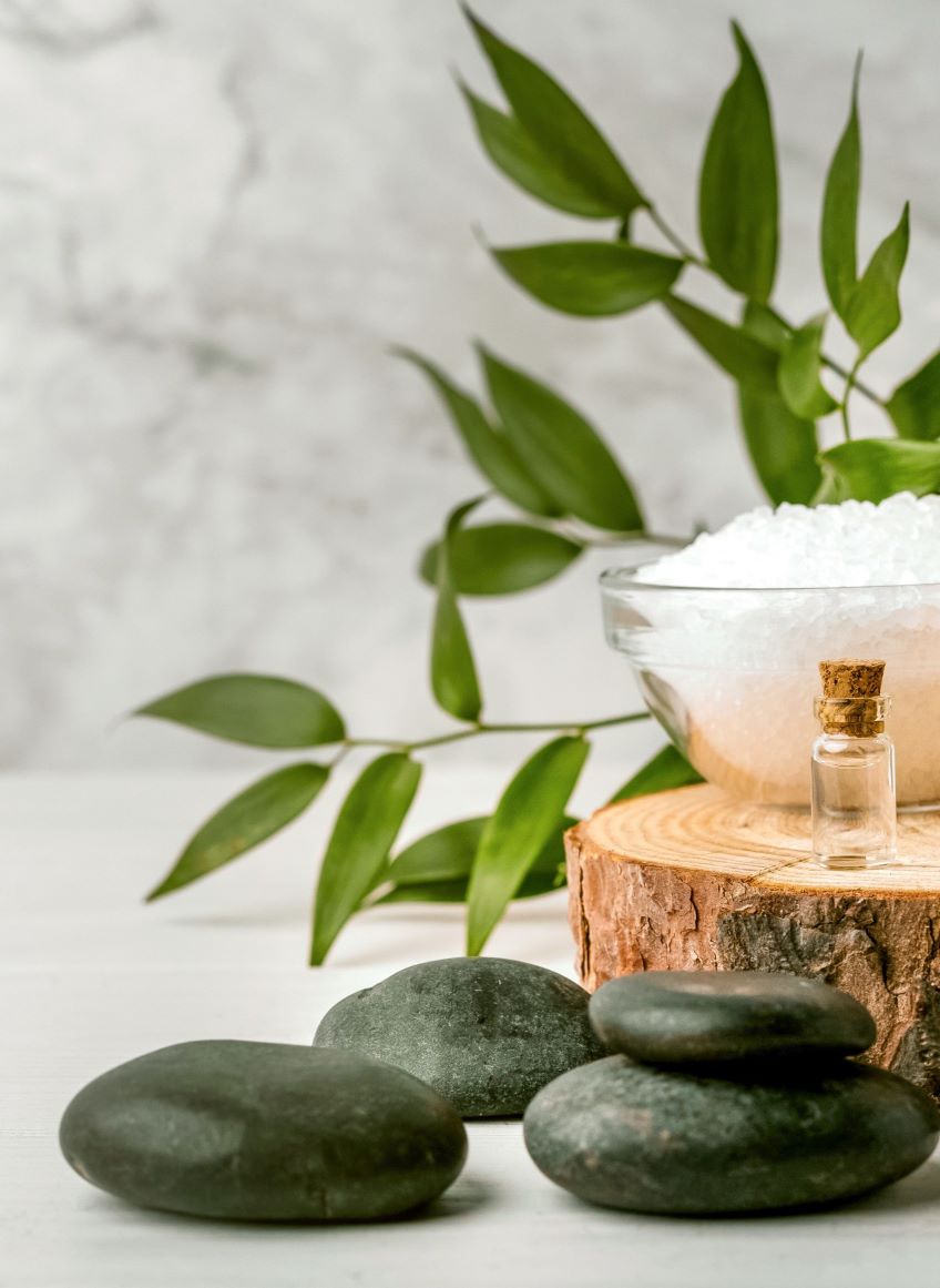 A bowl of salt and some rocks on a table.