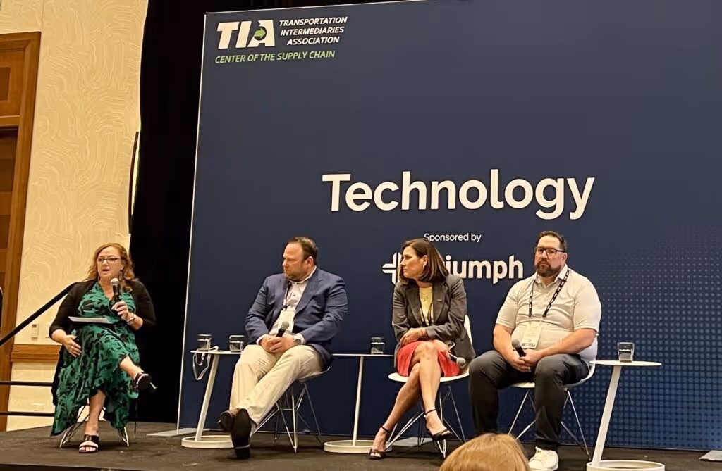 Panel discussion "You've Selected New AI Tech—Now What?" at TIA event, featuring four panelists on stage with blue background. 