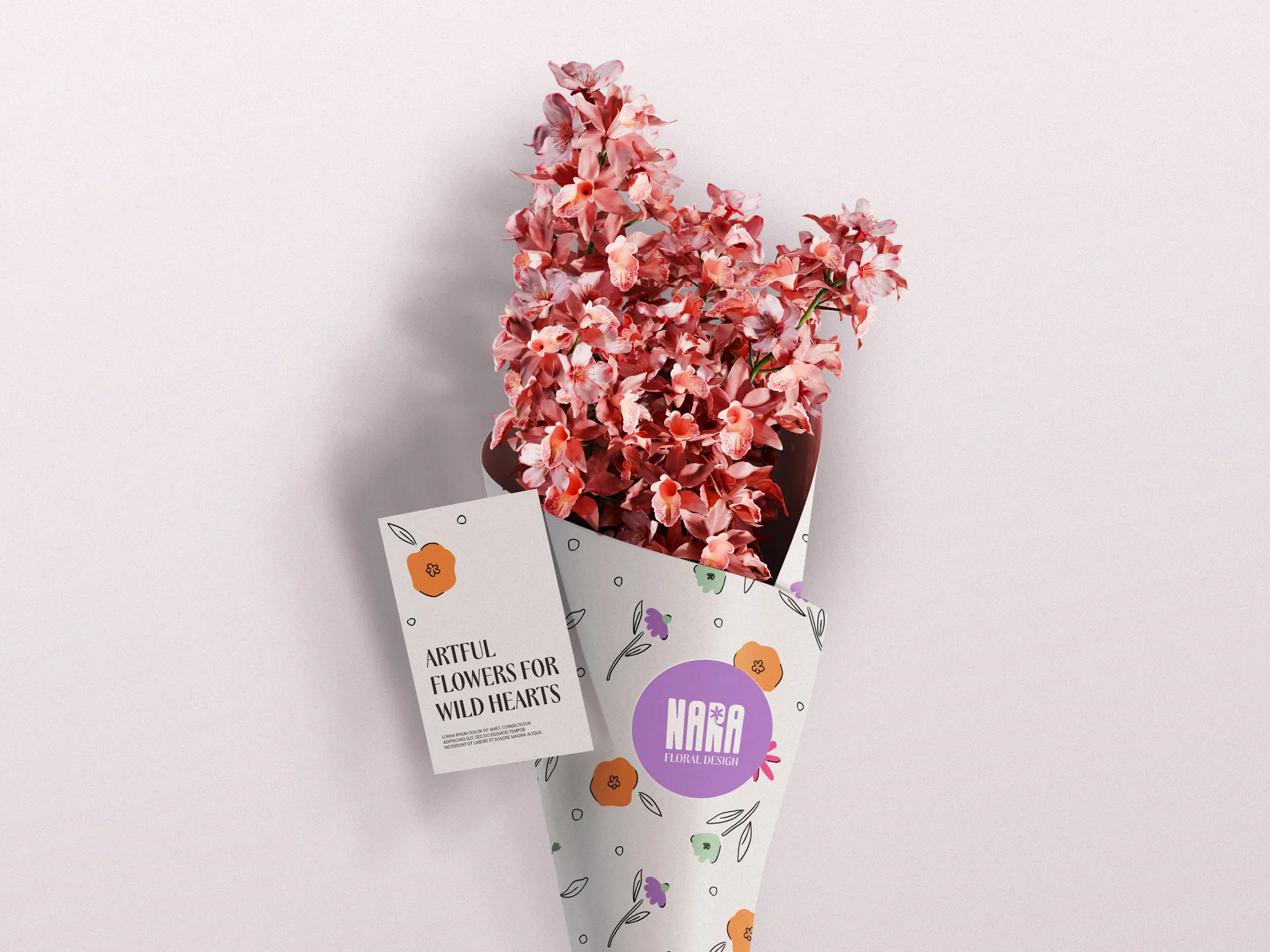 Bouquet of pink flowers wrapped in floral patterned paper with a tag reading 'Artful Flowers for Wild Hearts' from Nara Floral Design.