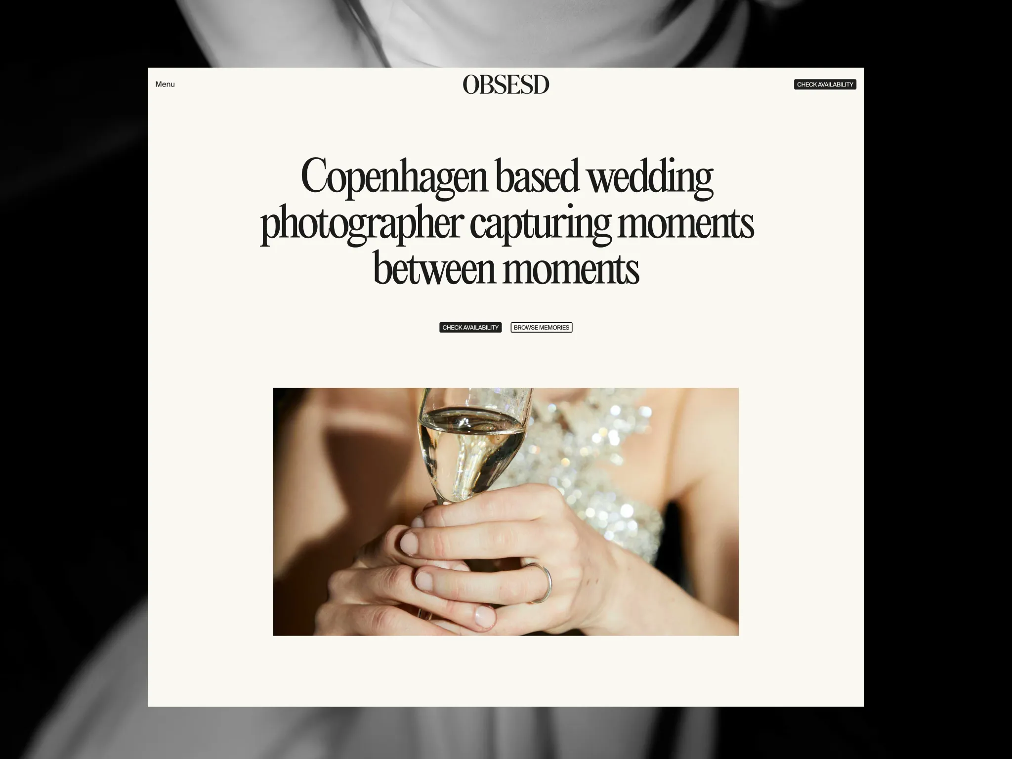 Close-up of hands holding a glass of champagne, with a blurred sparkling dress in the background.