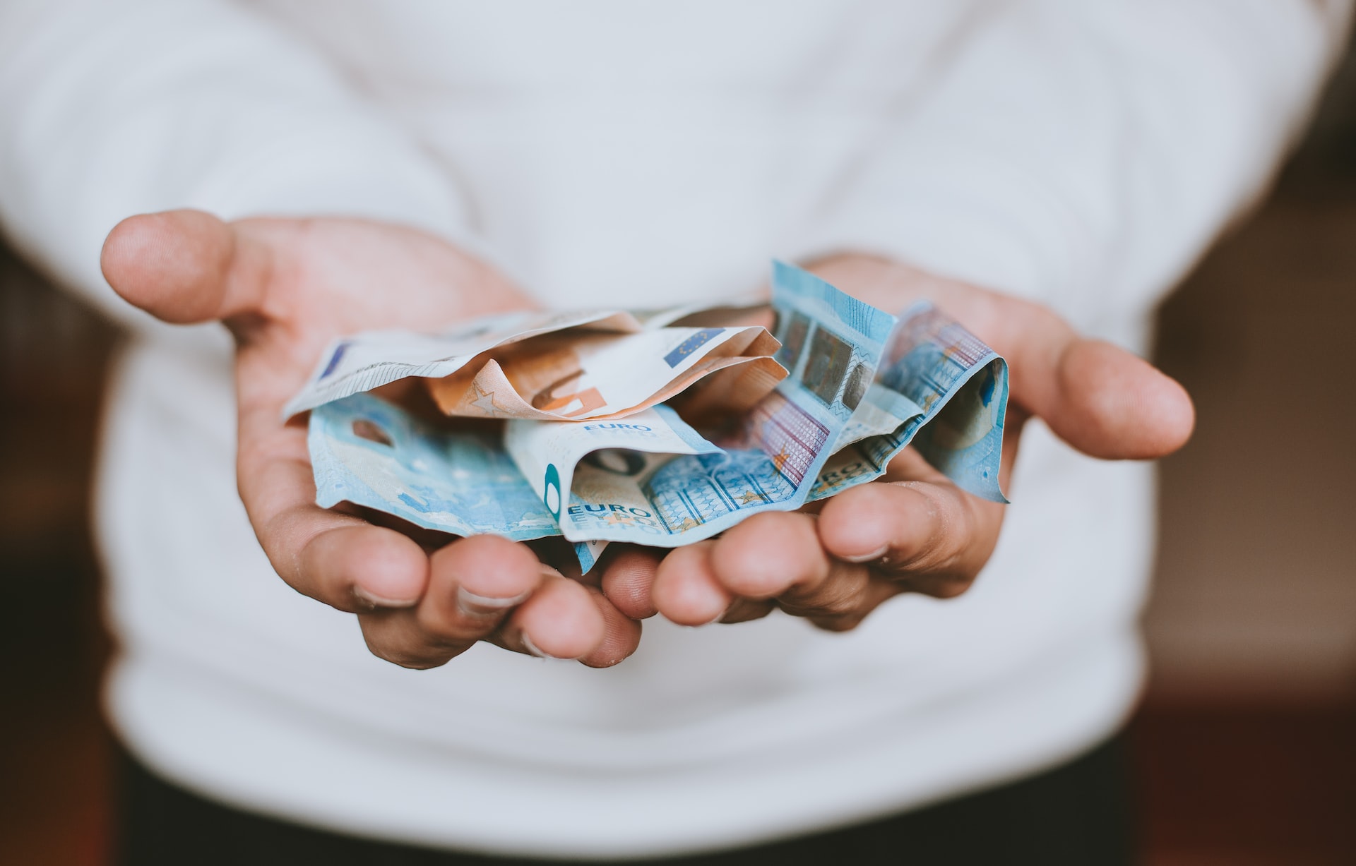 Zwei offene Hände mit Euro-Scheinen