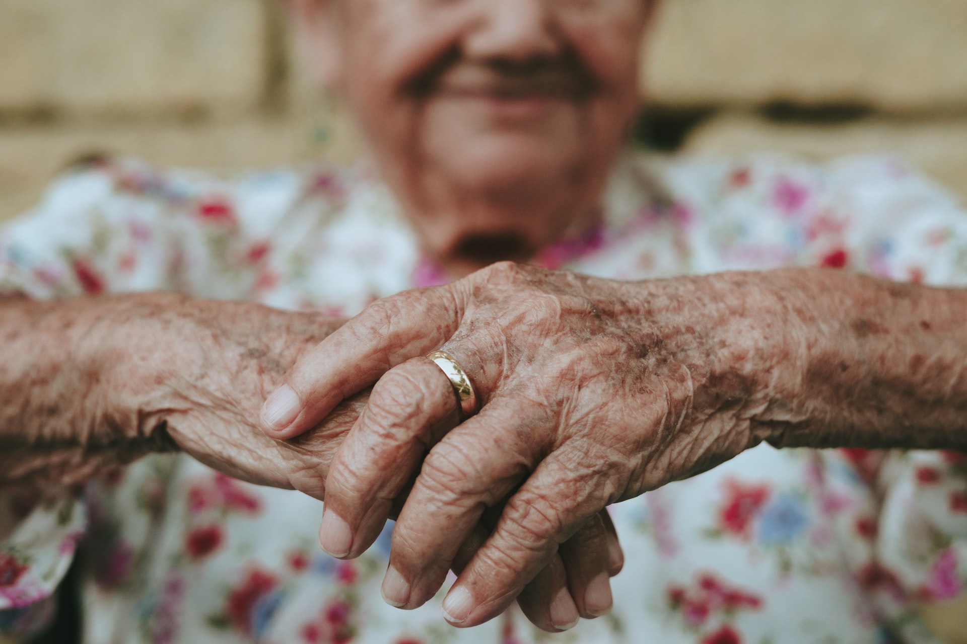 Hände einer alten Dame mit einem Goldring