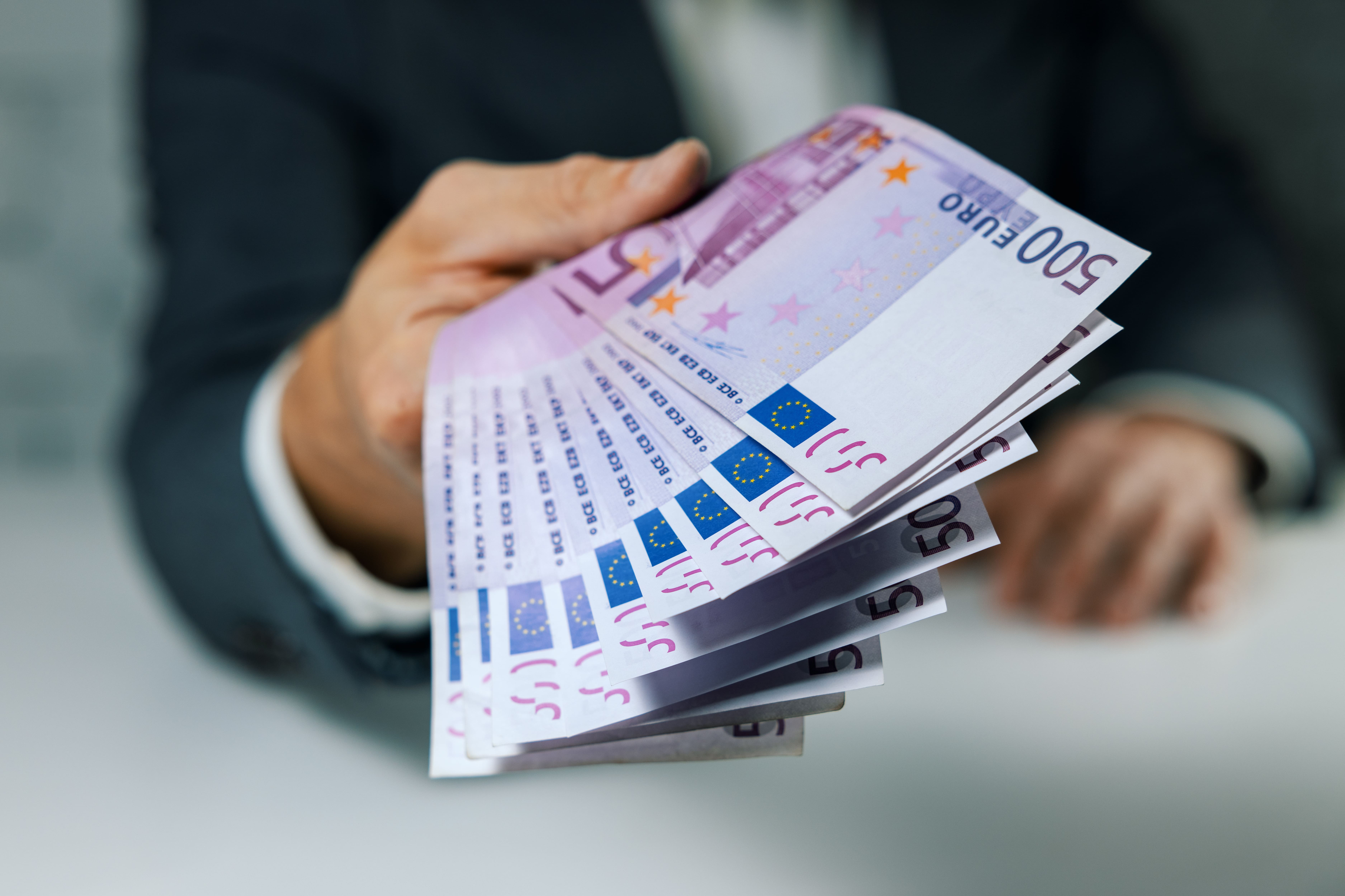 500-Euro-Banknoten in die Hand geben