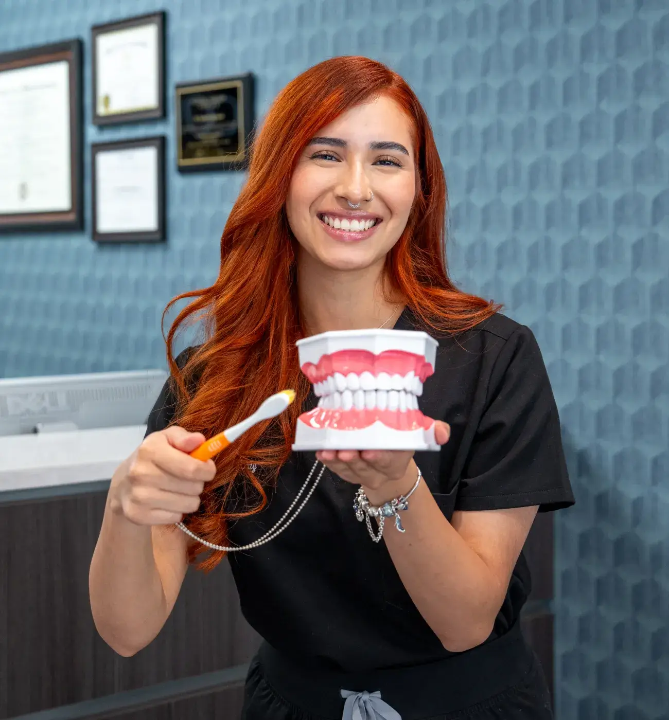 A receptionist waves to a woman standing across the counter in a waiting area.