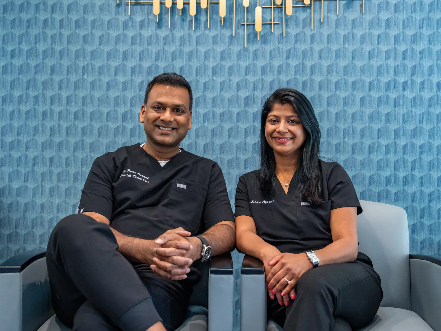 A smiling woman holding a plush toy with a crown and wings.