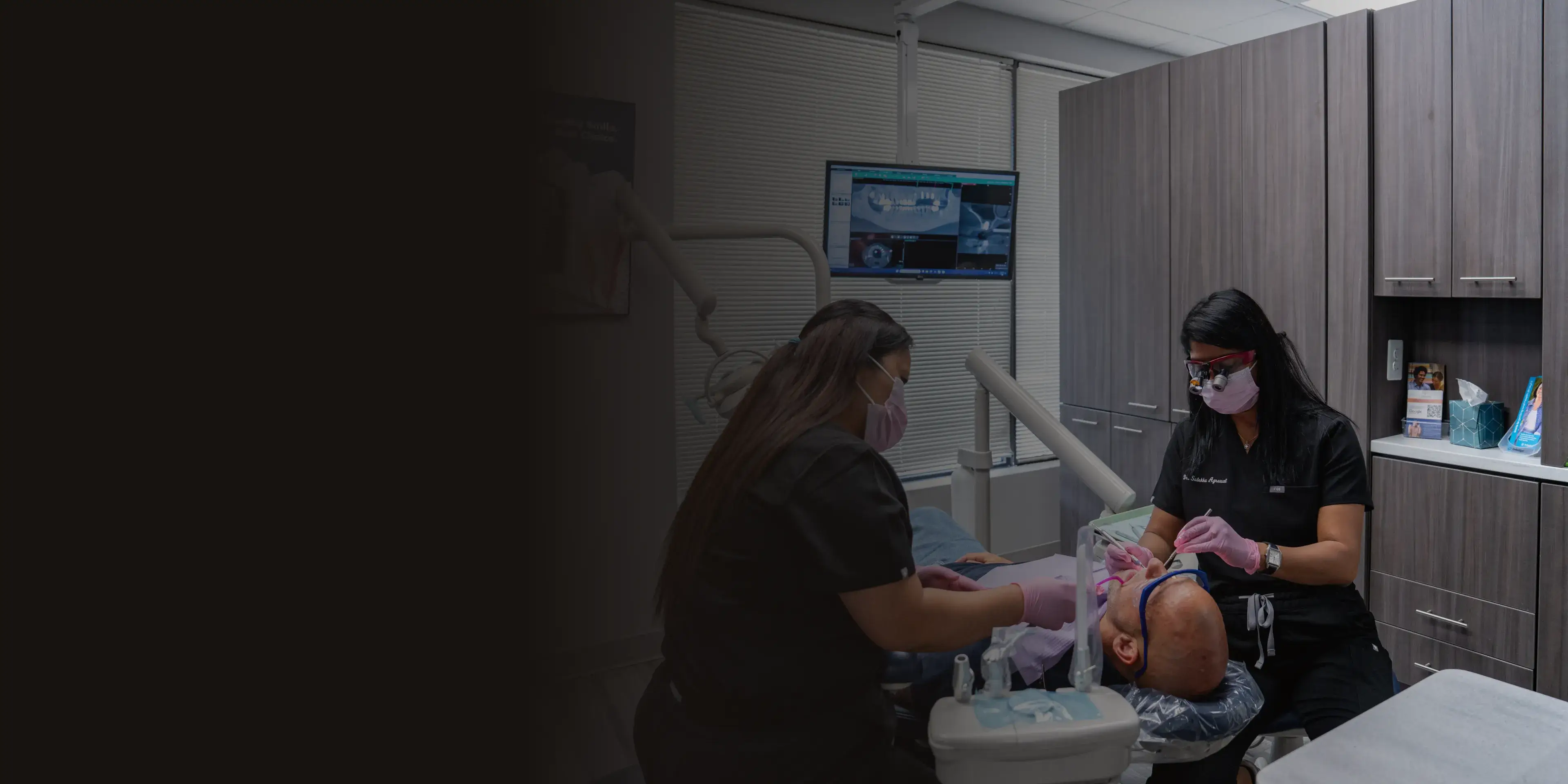 A dental professional wearing a mask examines a patient's mouth with dental tools.