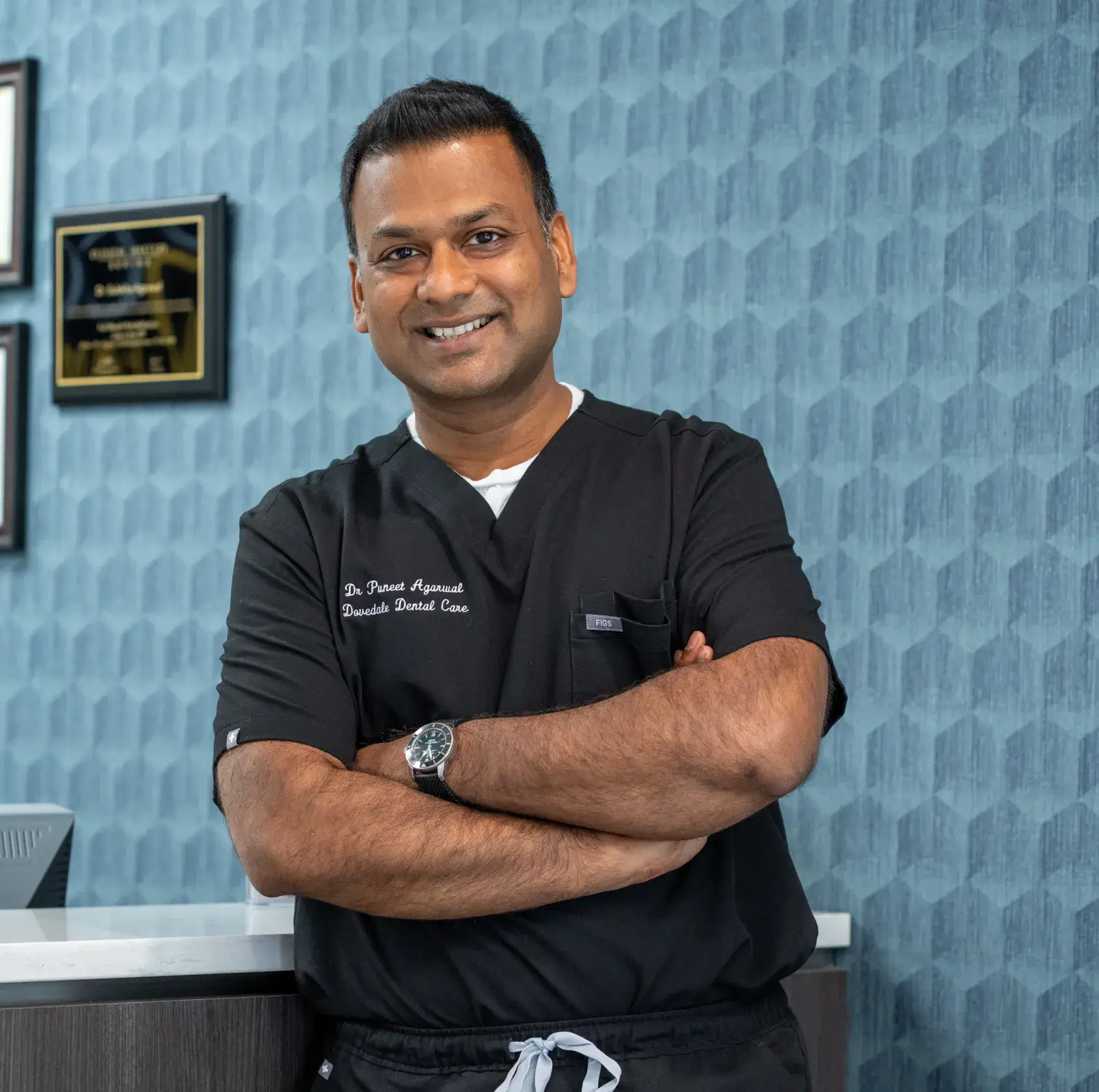 Two dental professionals in masks and gloves working on a patient in a dental office.