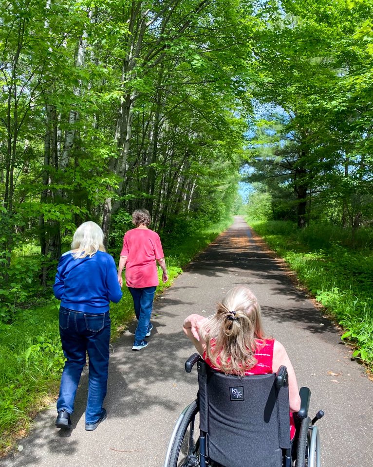 Three residents walking outside on the trail
