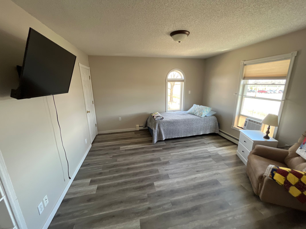 Interior of a bedroom with natural light and a tv