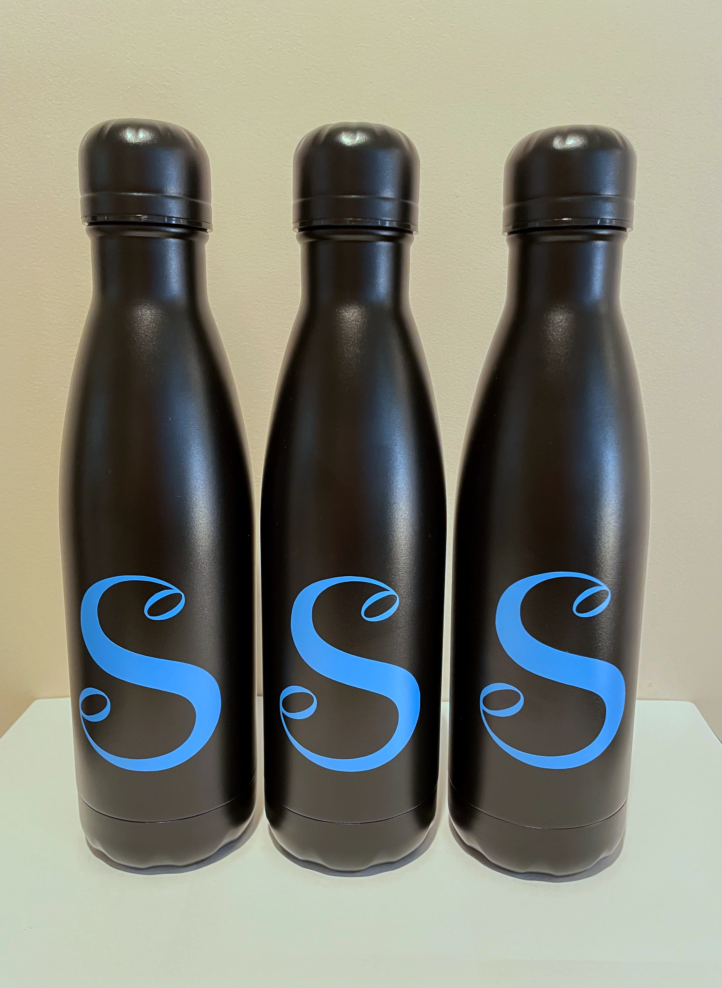 Three water bottles with 'S' logos