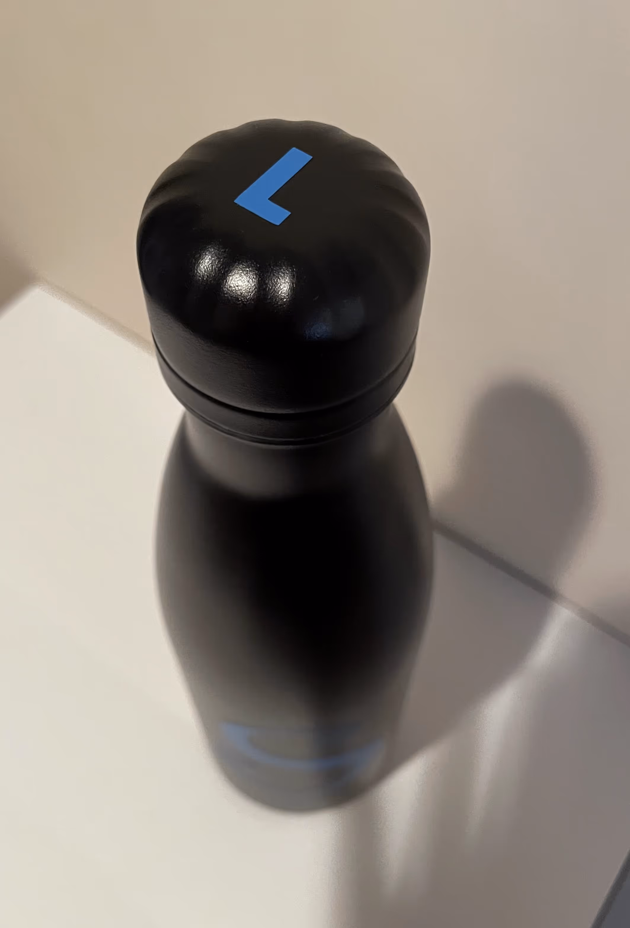 Water bottle with 'S' logo on the bottle and initial on the lid