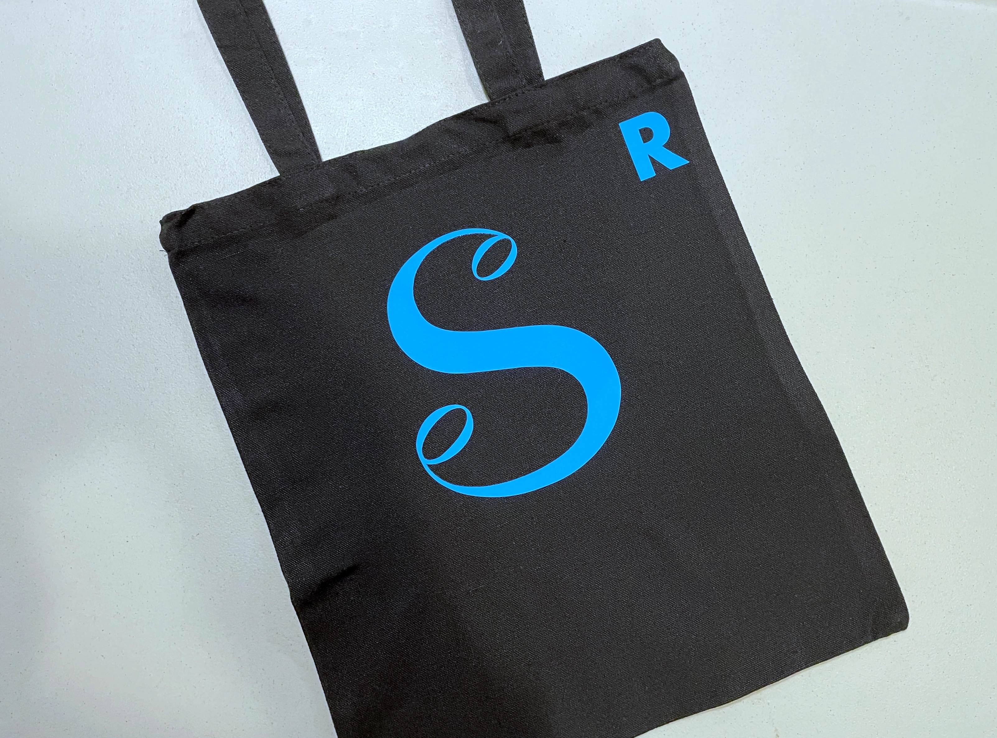 Black bag with blue "S" logo and smaller 'R' initial