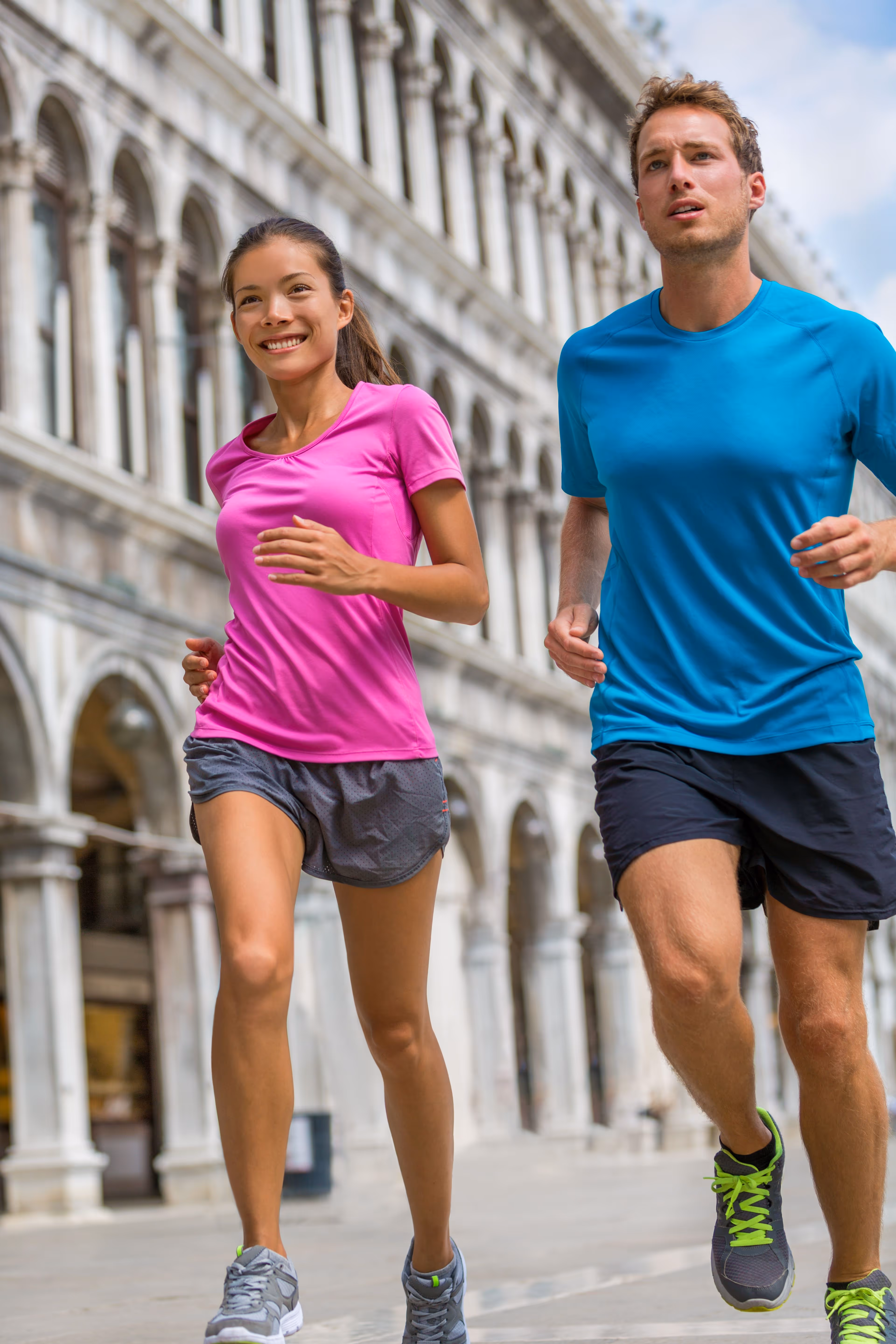 A man and a woman running in front of a building.