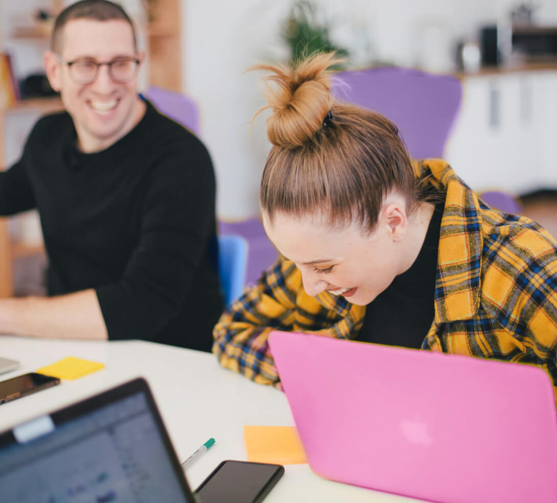 Co-workers enjoying a laugh at a meeting.