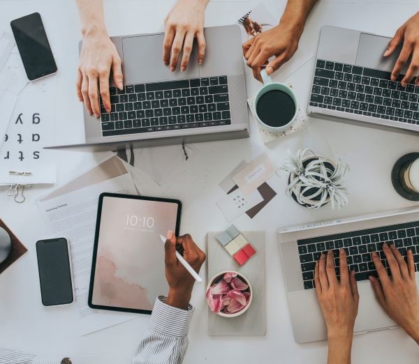 A bunch of devices on a table with people working.  Are these devices managed? They should be!