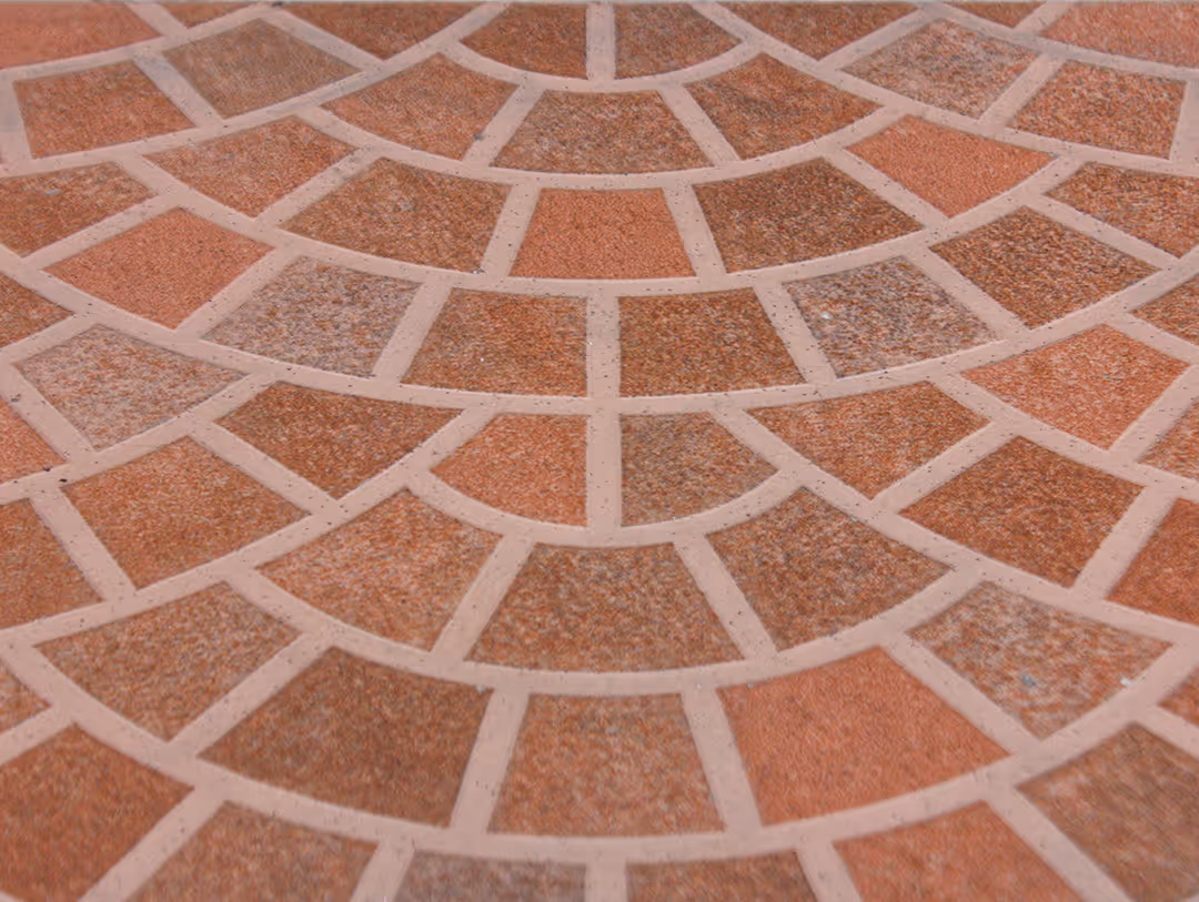 Curved pattern of reddish-brown and tan mosaic tiles set in light grout.