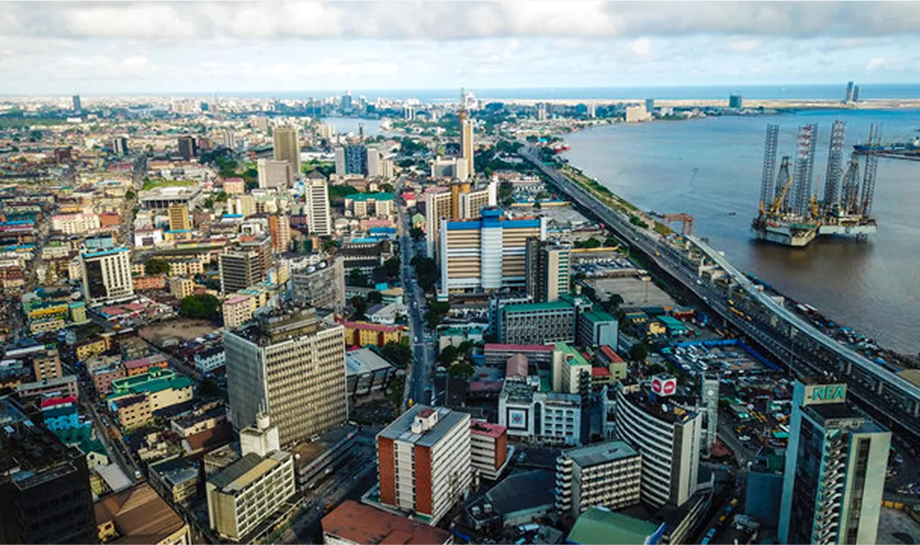 Aerial view of Lagos, Nigeria showcasing the city’s central business district, coastline, high-rise buildings, and the bustling Third Mainland Bridge stretching over the lagoon.