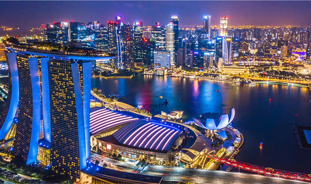 Stunning night view of Singapore’s Marina Bay skyline featuring the Marina Bay Sands hotel, ArtScience Museum, and brightly lit financial district reflected on the waterfront.