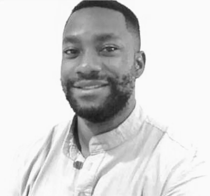 Black and white portrait of Chuka Christopher Ilochi, Founder and Chief Executive Officer, smiling and wearing a light-colored shirt against a plain white background.