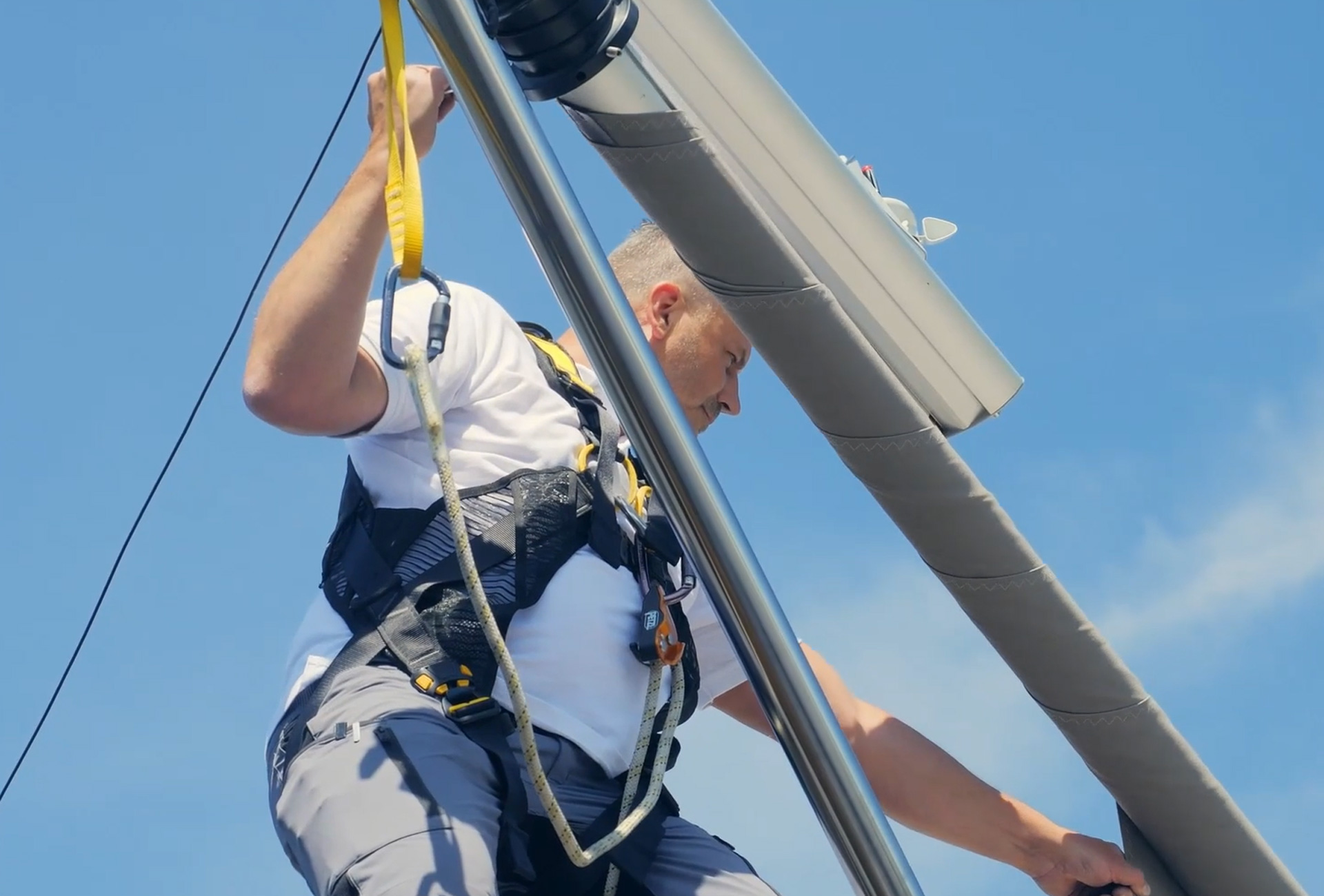 Hier sieht man einen SunSquare Monteur, der als letzten Schritt in der Fertigstellung einer Anlage das Segeltuch aufzieht.