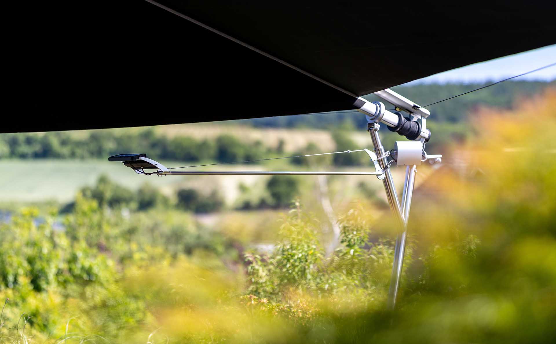 Montierte SQLED Leuchte an einer SunSquare Anlage – befestigt an Metallstruktur mit Kabelanbindung, ideal für stimmungsvolle Außenbeleuchtung