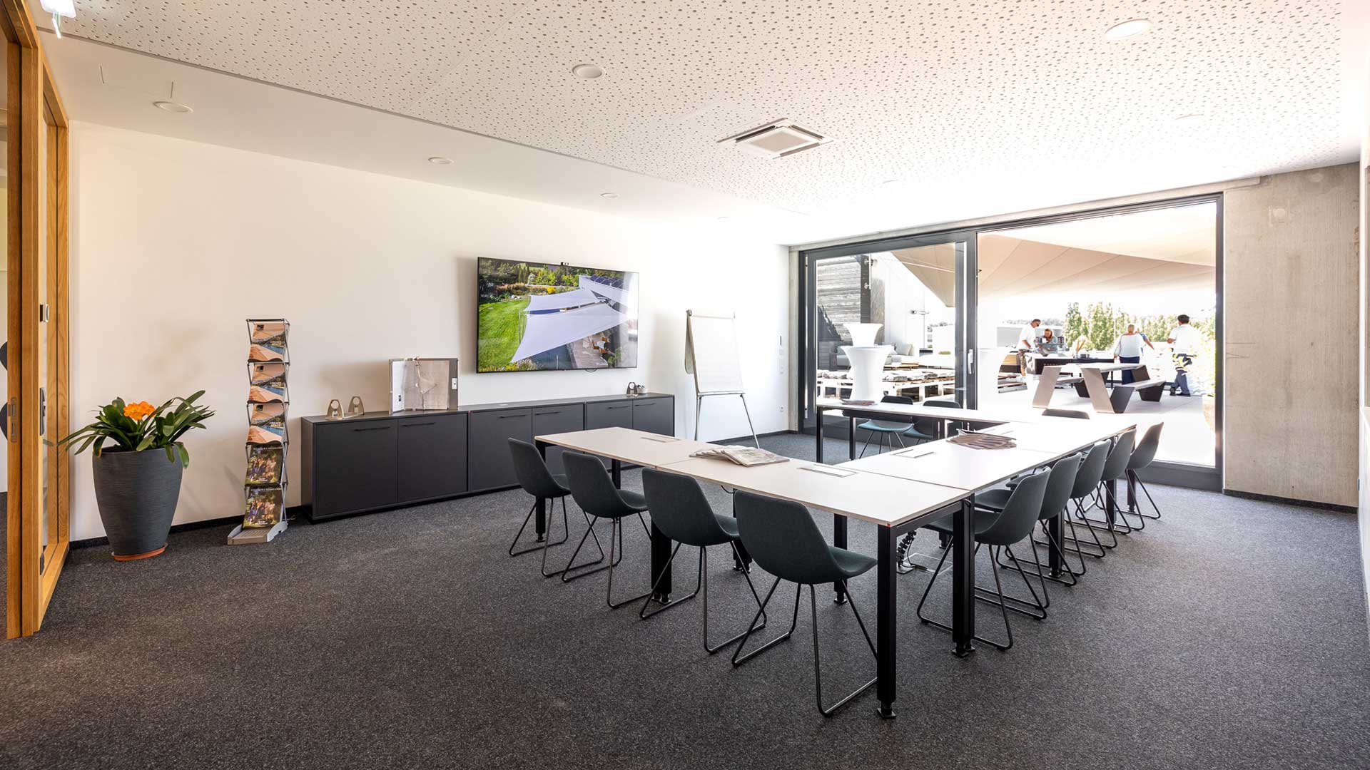 Moderner Besprechungsraum im SunSquare-Headquarter mit großem Bildschirm für Videokonferenzen und Präsentationen, hellen Lichtverhältnissen und komfortablen Sitzmöglichkeiten – ideal für produktive Meetings.