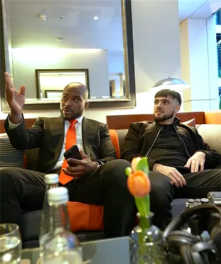 A couple of men sitting on top of a couch.