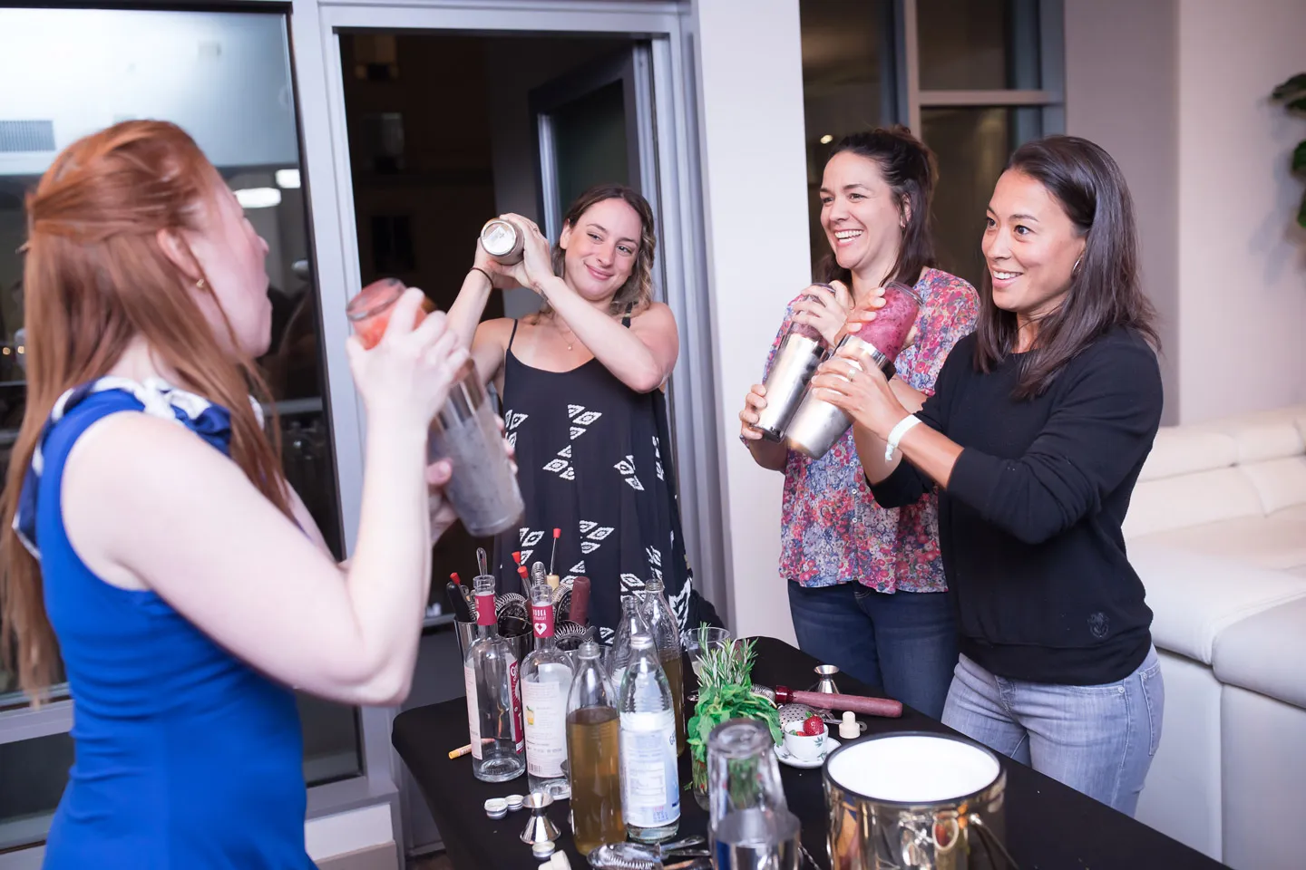 Group of people using beverage shakers to mix drinks together.