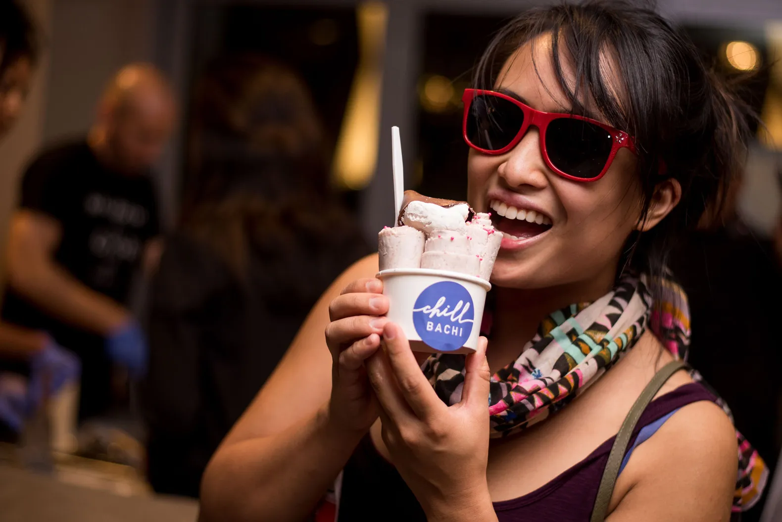 Person smiling at their ice cream cup labelled "chill BACHI".
