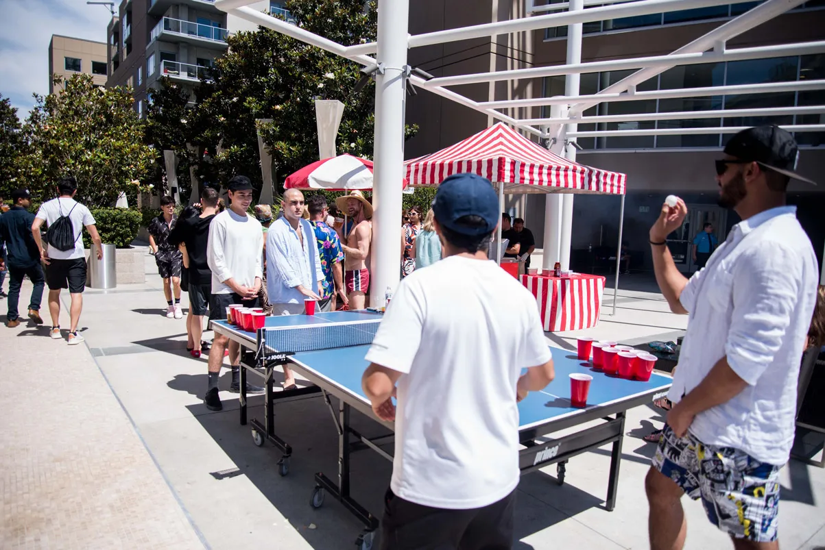 Group gathered at an outdoor ping pong table.