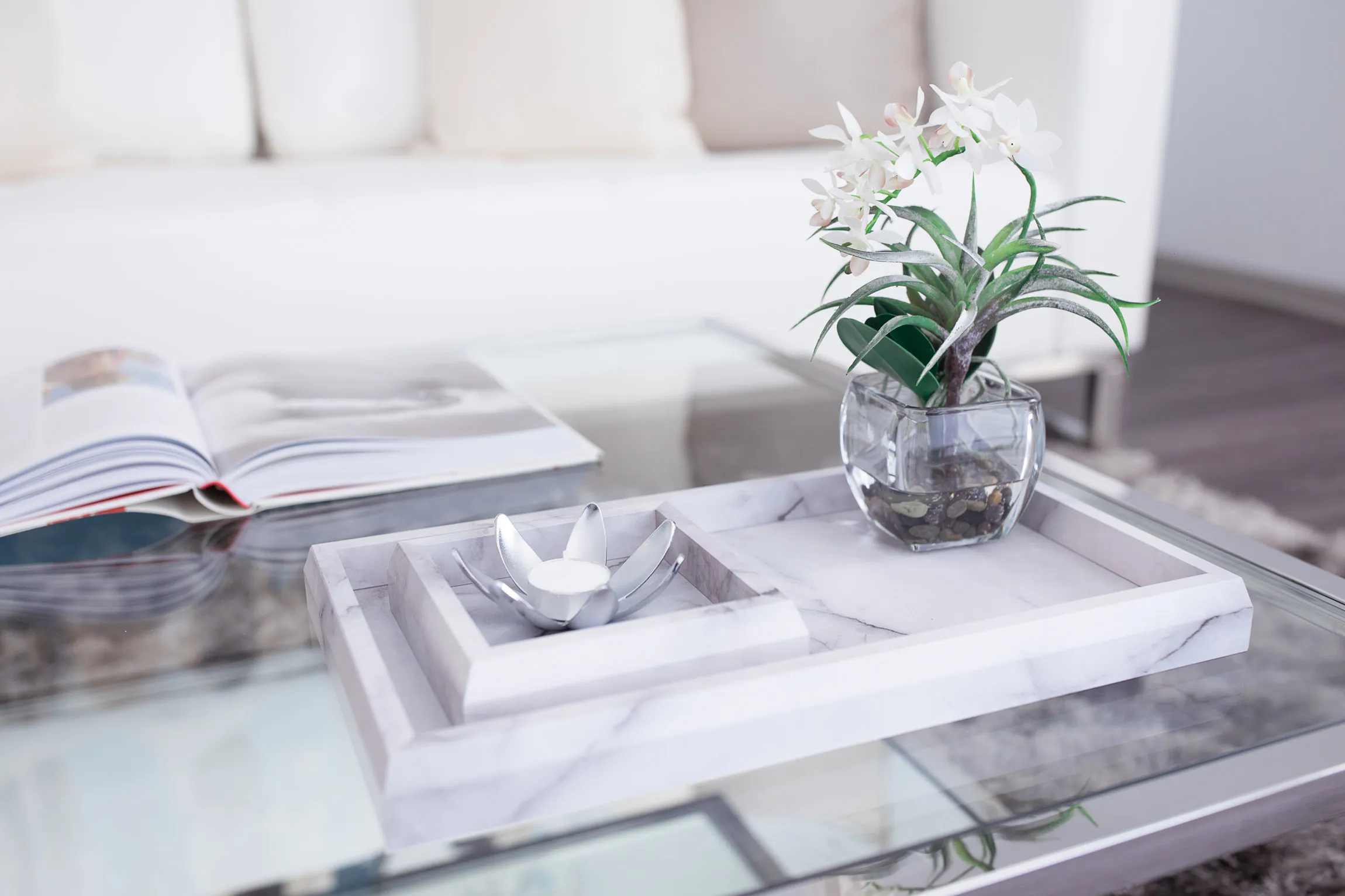 Close up of marble decorations sitting on top of glass table.