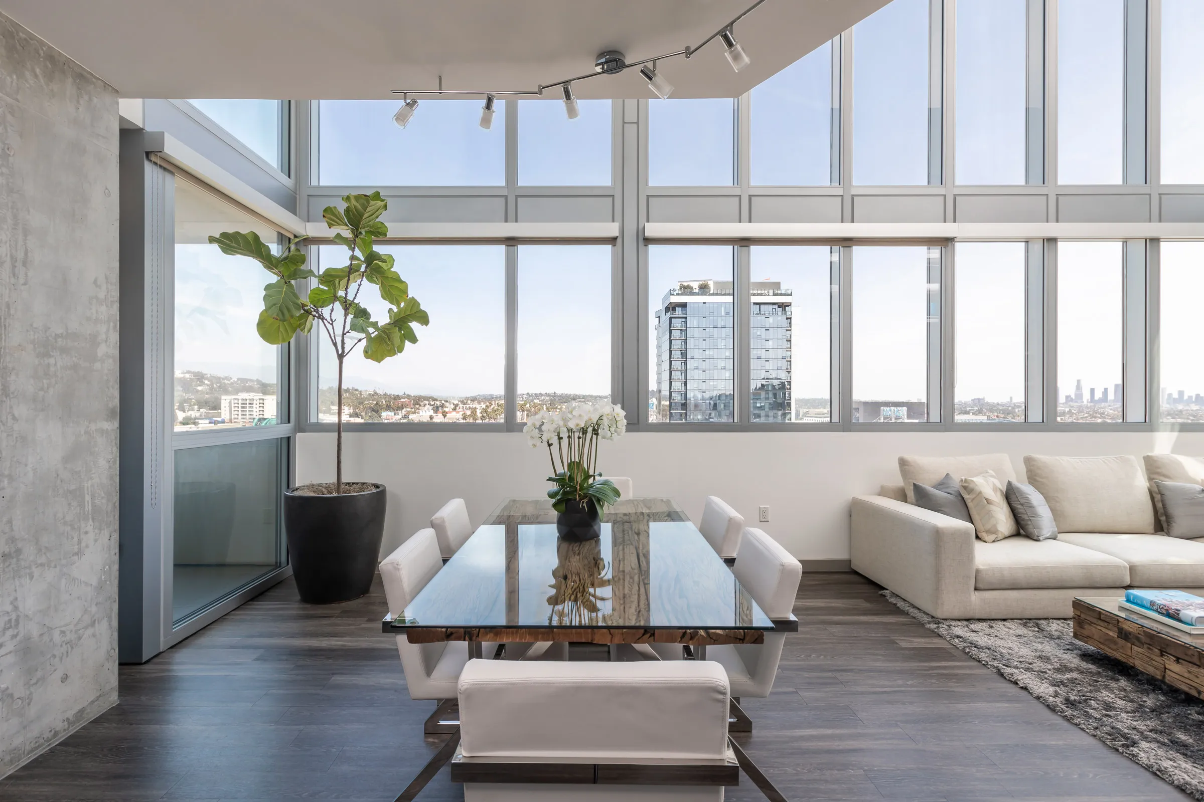 Spacious glass dining table overlooking a cityscape.