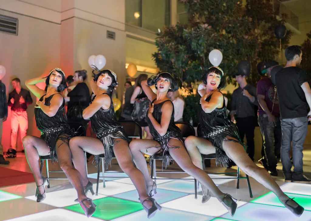 Female dancers dancing in formation at a nighttime event