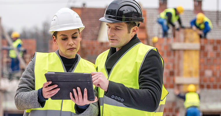 Two engineers looking at a tablet
