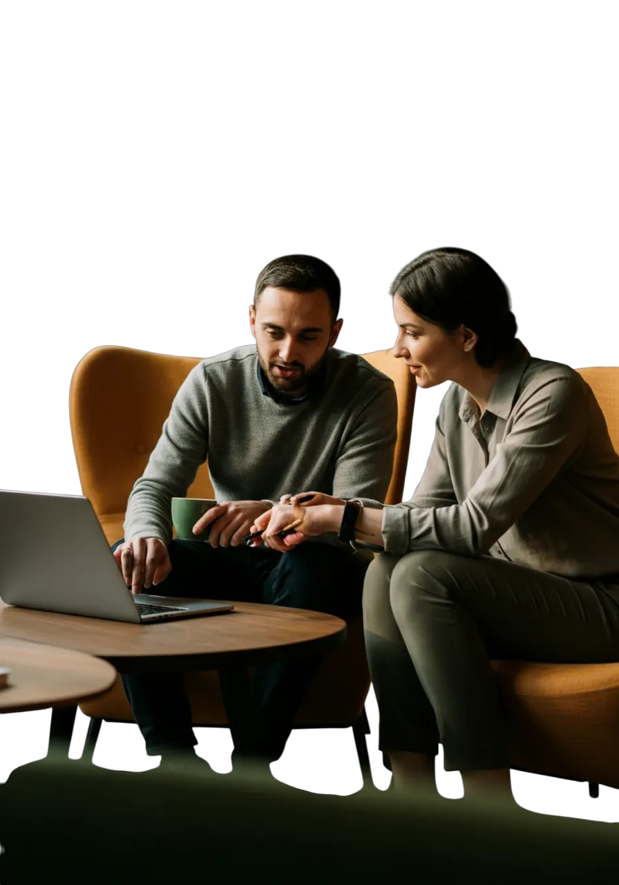 Two marketing professionals seated in a modern lounge area, reviewing a strategy on a laptop while discussing growth opportunities over coffee