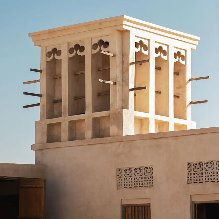 Traditional Middle Eastern wind tower made of beige stone against a clear blue sky. Invest in Ras Al Khaimah Luxury Real Estate