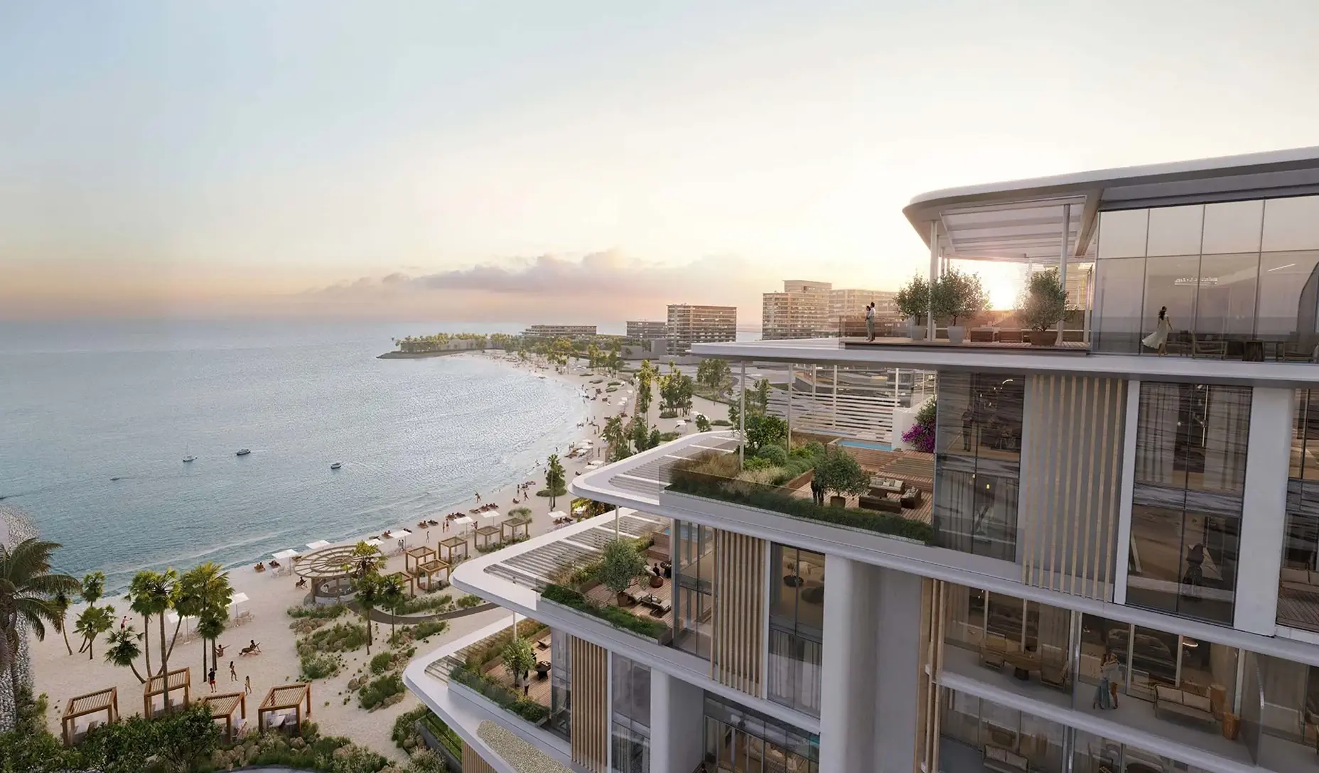 Modern beachfront architecture with terraces overlooking a sandy beach and calm sea at sunset.