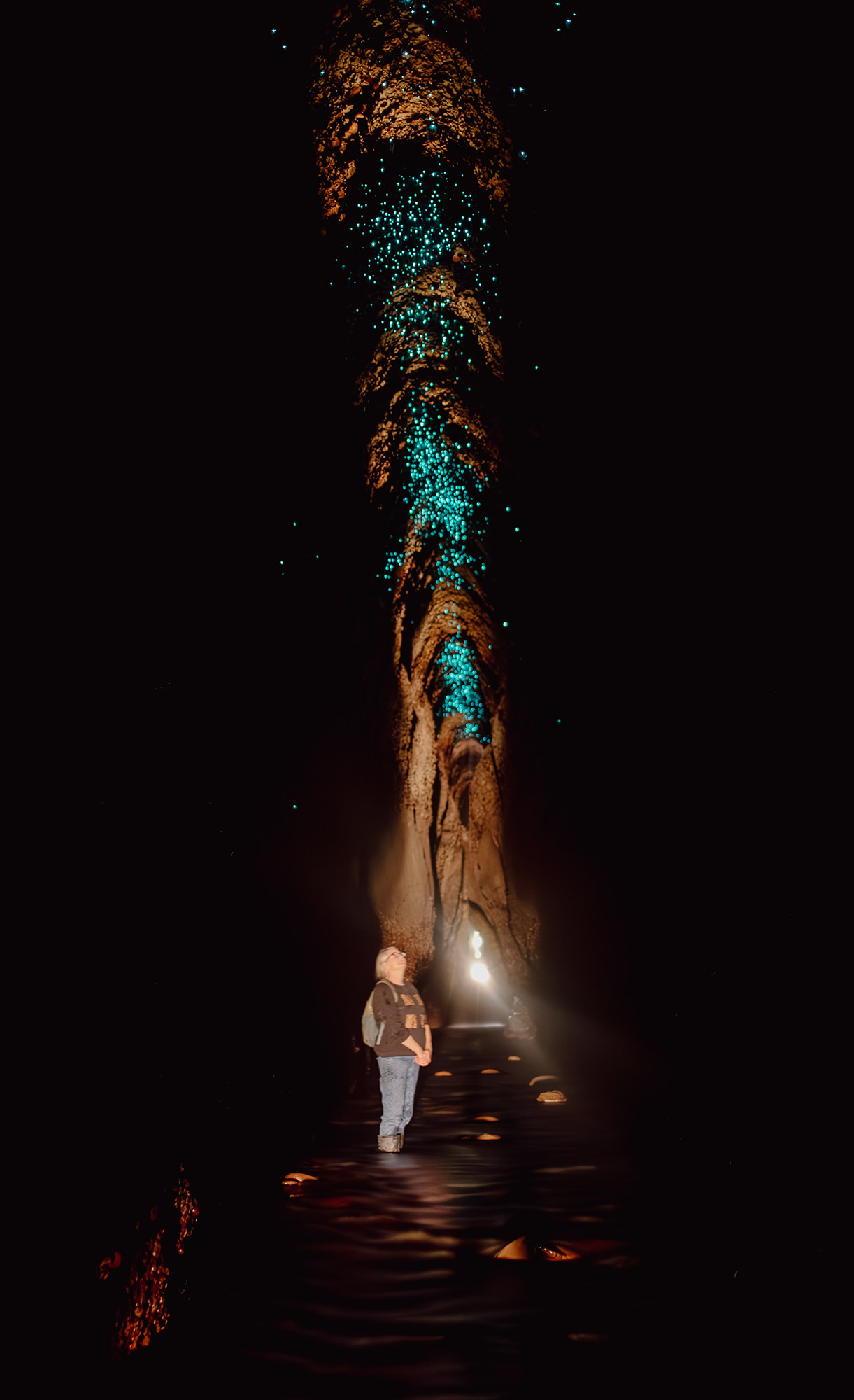 woman looking at glowworms in tunnel
