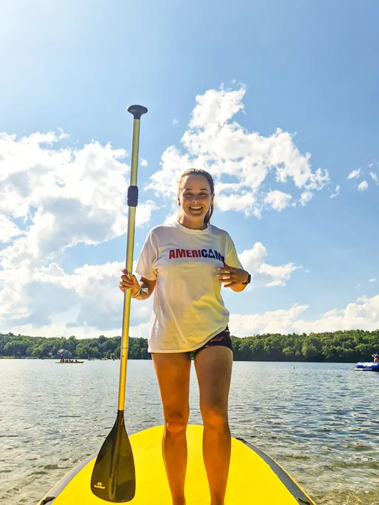 Australian student enjoying paddle boarding activities at a USA summer camp for AmeriCamp.