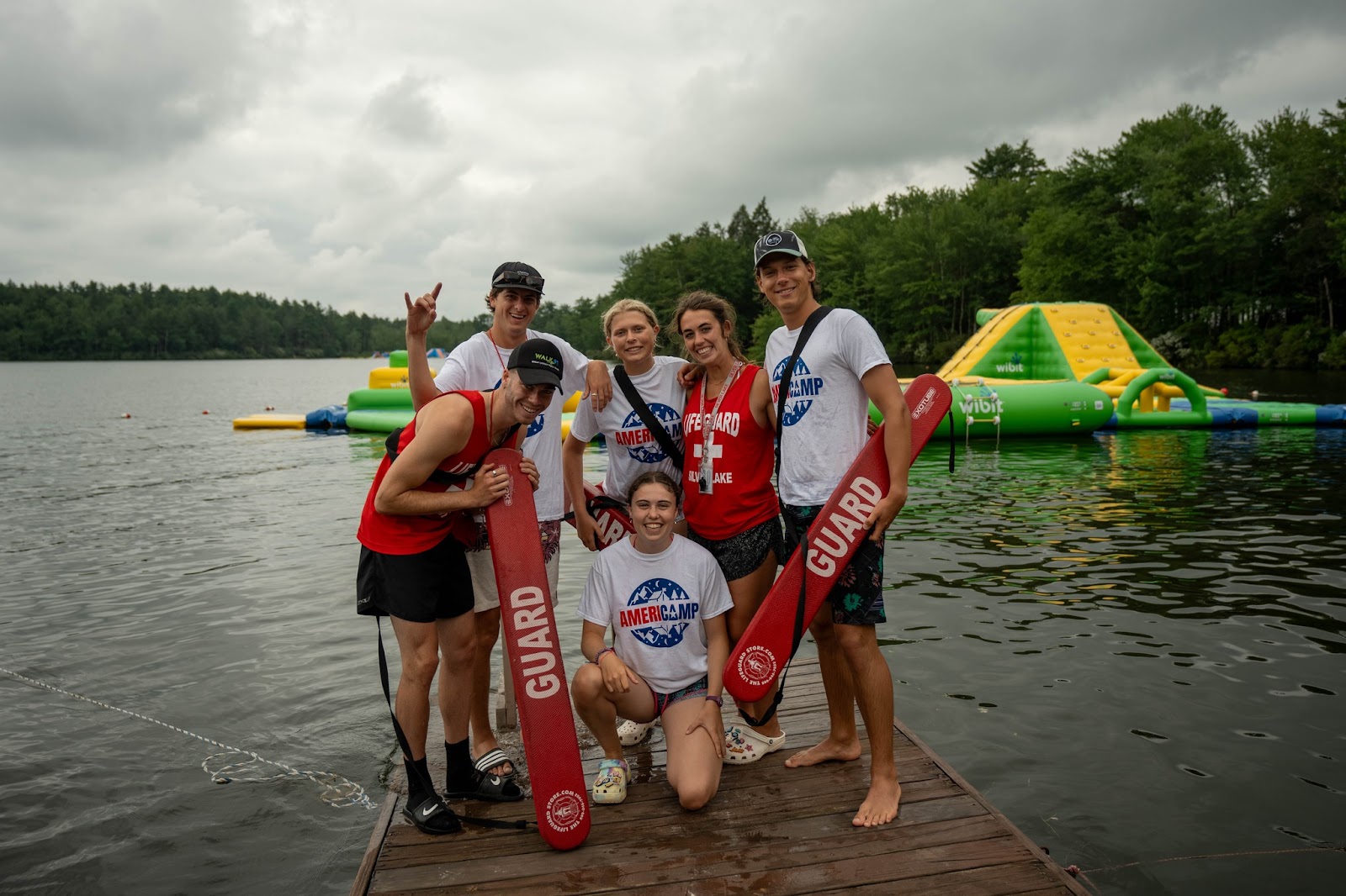 A group of AmeriCamp counselors pose for a picture on floating platform in the middle of a lake.