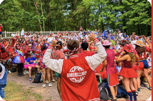 A large group of campers, including someone in the foreground in an AmeriCamp jacket.