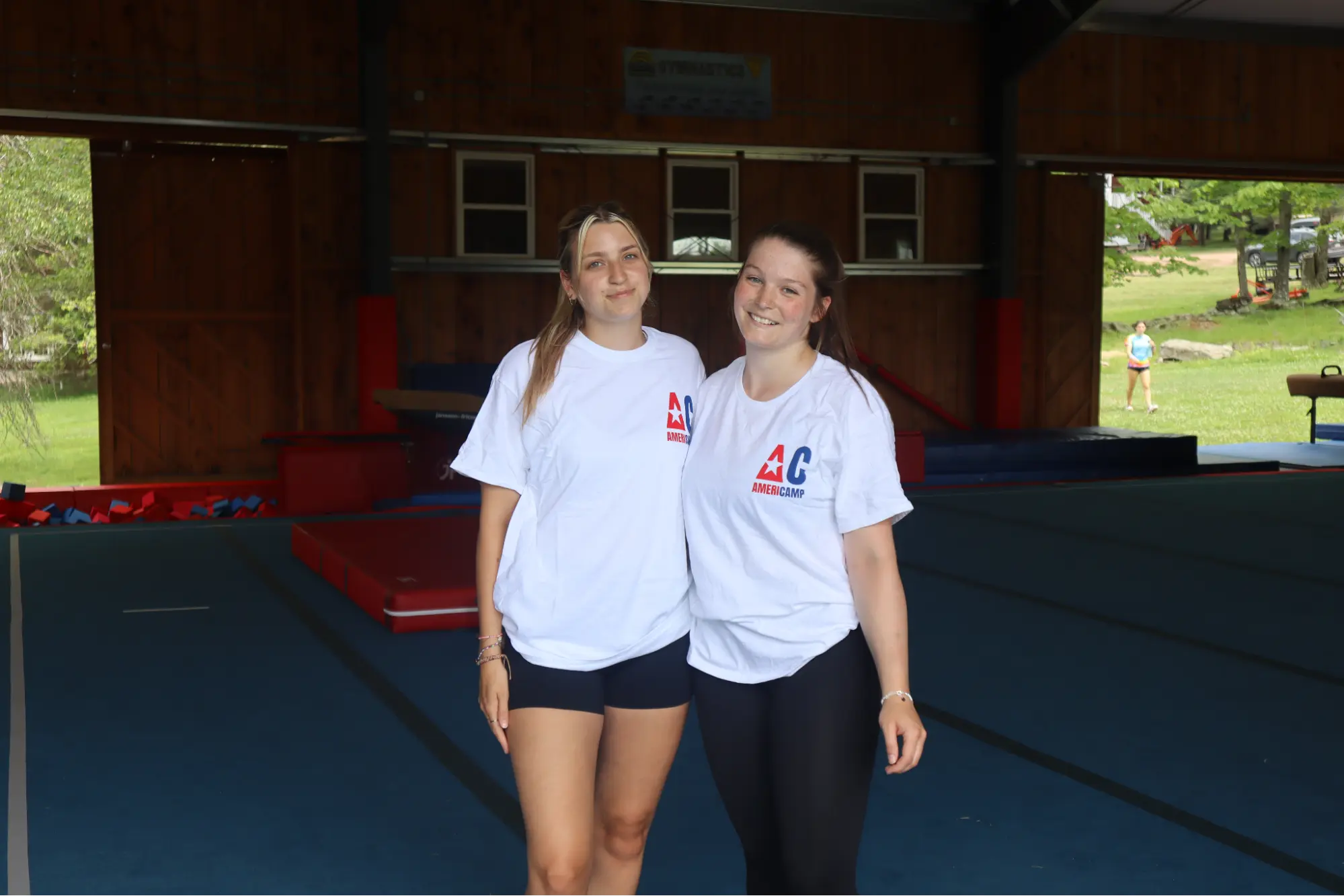 Two AmeriCamp counsellors pose for a photo together at camp