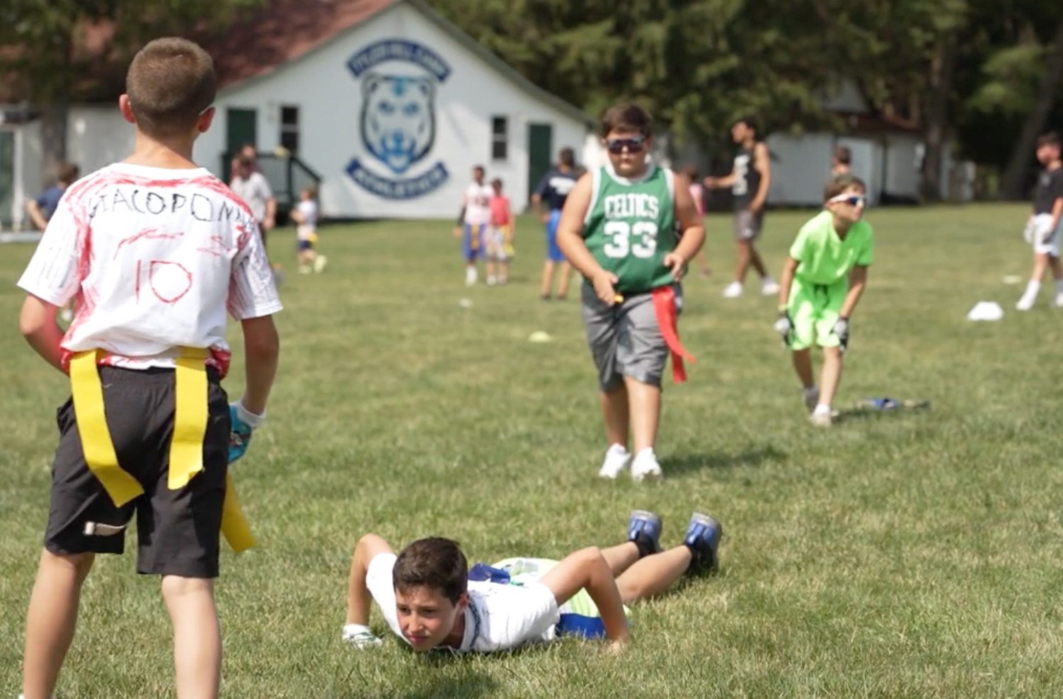 Summer camp participants playing flag football on a field