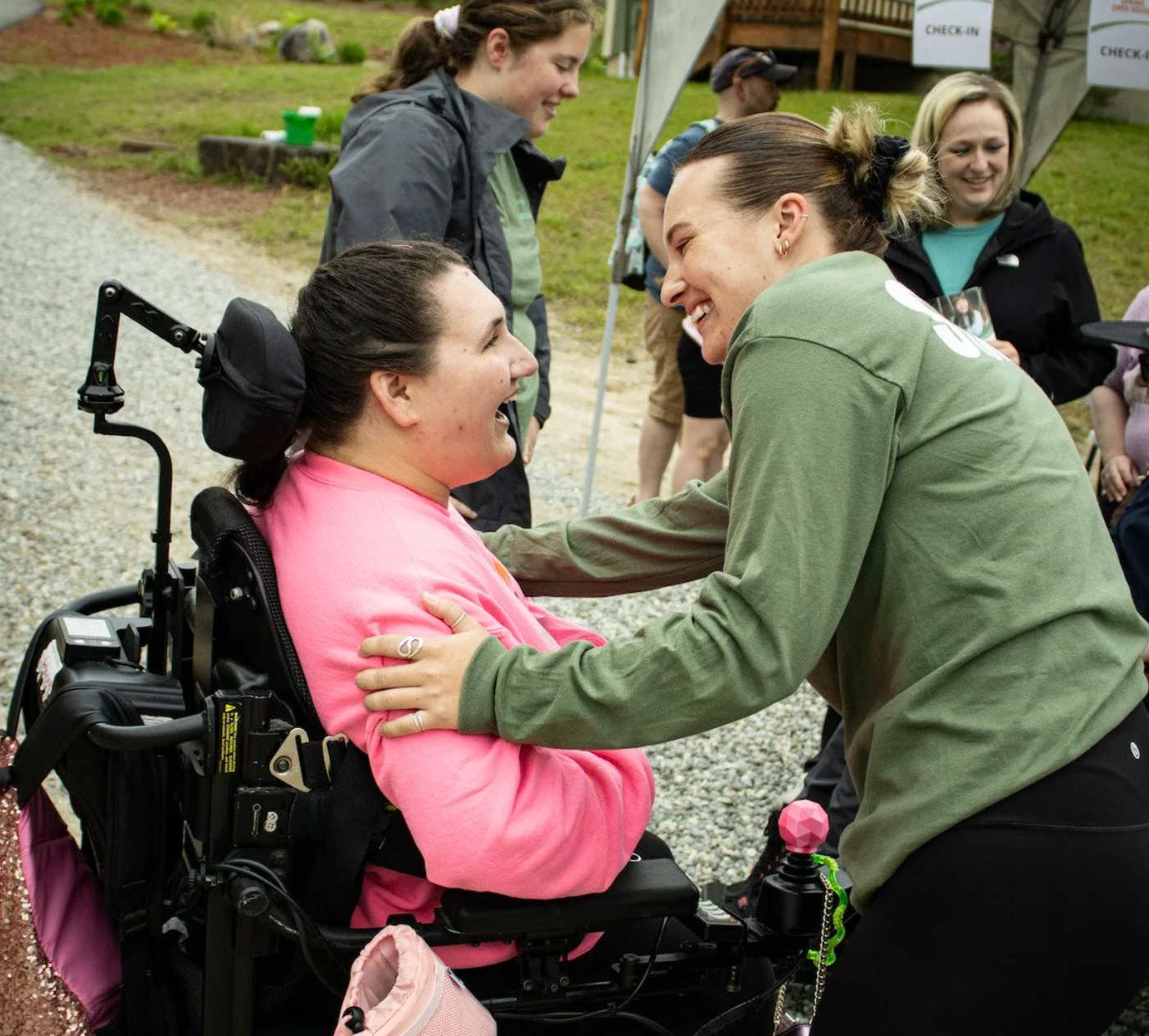 Camper in a wheelchair at Camp Allen laughs with a camp counsellor