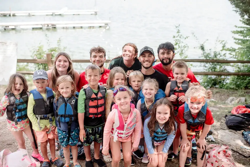 Campers and counsellors in life vests on the lakefront at Phantom Lake YMCA Camp