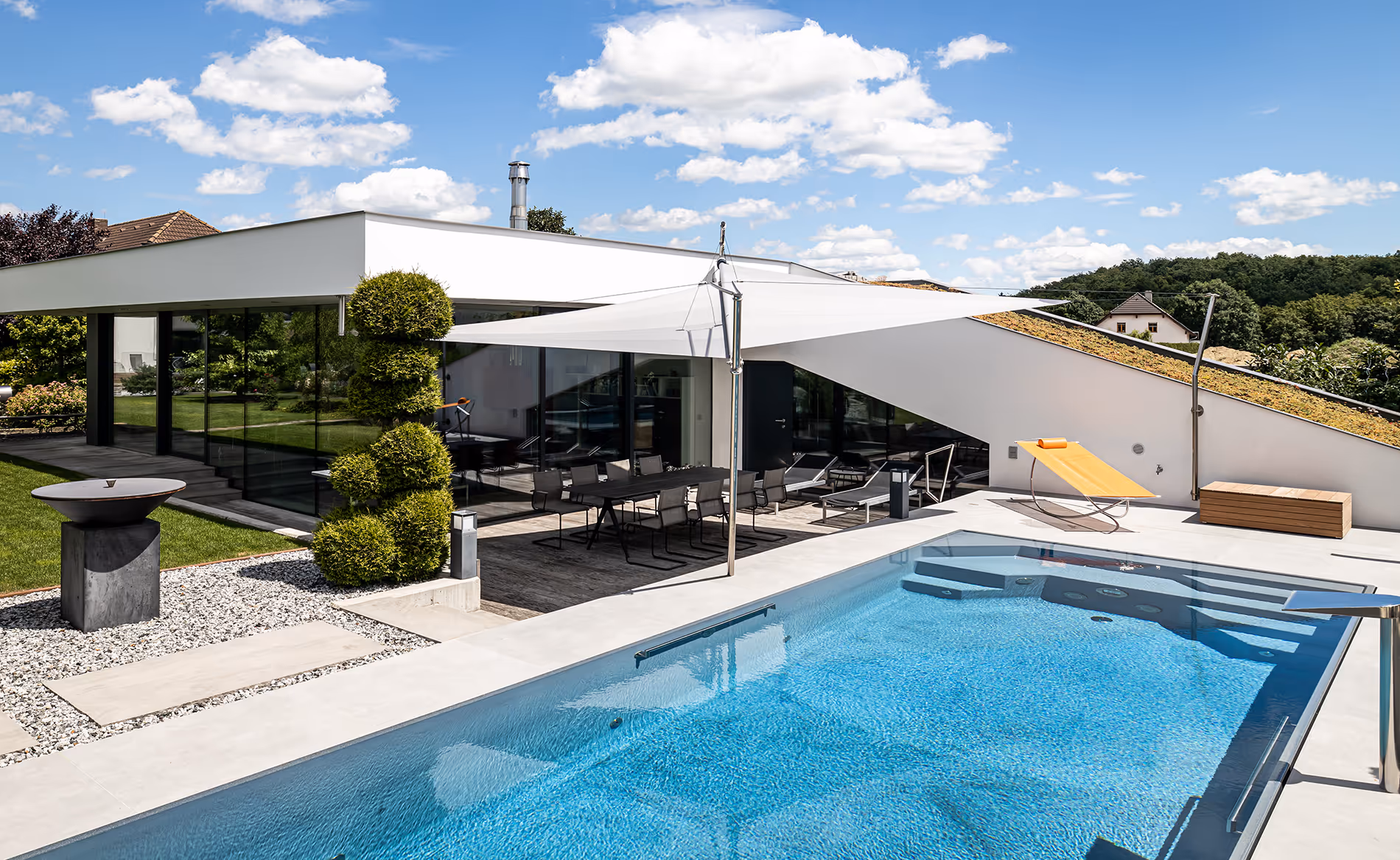 A SunSquare spring-tension system provides shade for both the seating area and the adjacent glass façade.