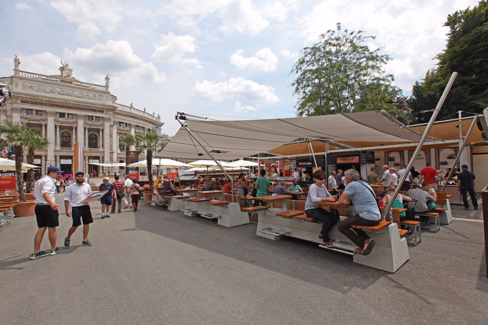 SunSquare sails on City Hall Square in Vienna at the film festival — numerous guests enjoy the shade in the dining area under the stylish sails.