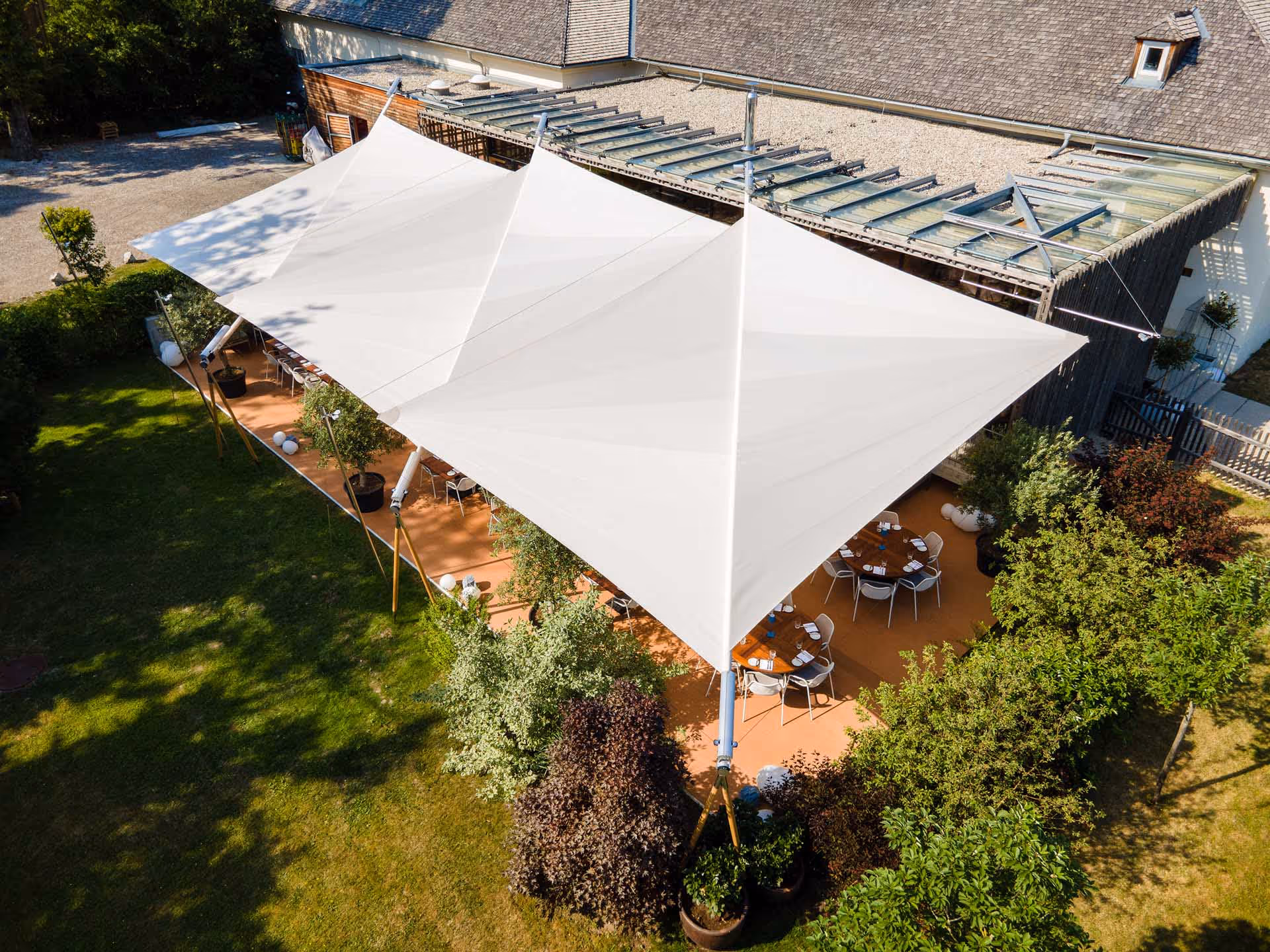 SunSquare Sonnensegelanlage mit über 200 m² Tuchfläche über dem Gastgarten des Chalet Moeller in Wien.