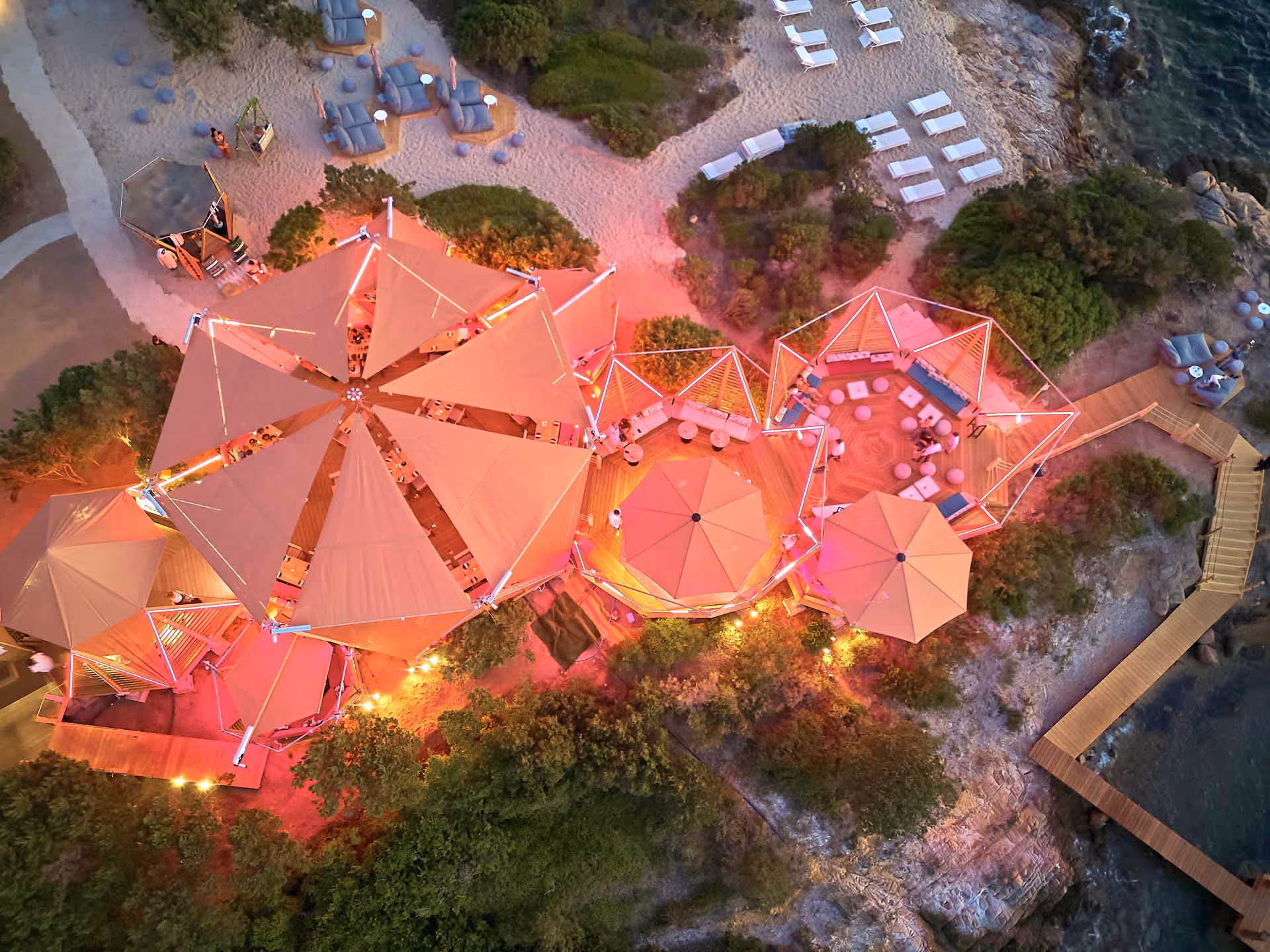 Stimmungsvolle Abendaufnahme mit beleuchteter SunSquare Anlage im Cone Club Sardinia.