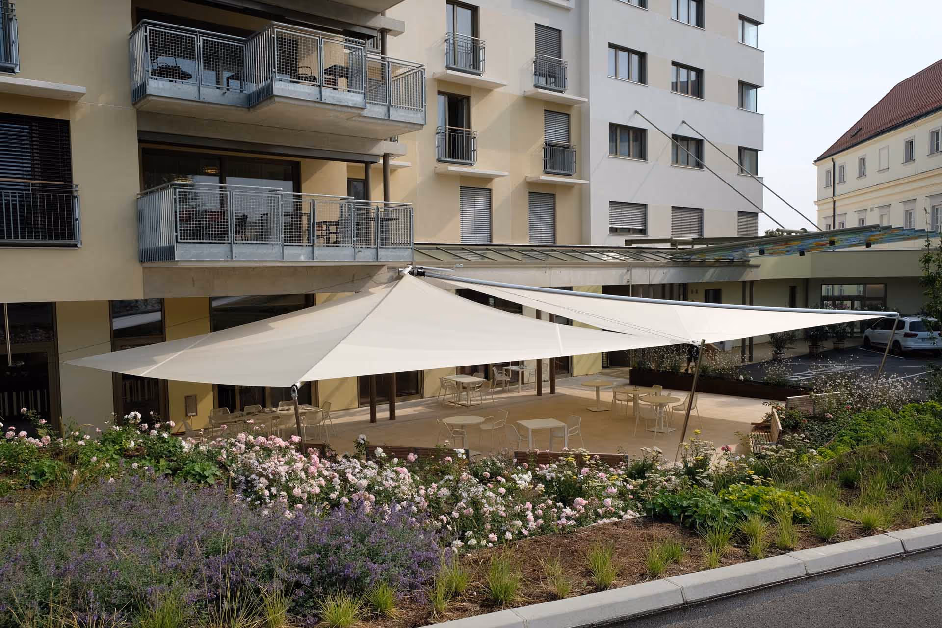 Markisen machen hier, im Pflegeheim in Kritzendorf keinen Sinn, sie könnten die notwendige Fläche niemals beschatten - daher kamen SunSquare Sonnensegel von SUNSYSTEMS ins Spiel. Großflächiger Schatten und der Kaffee lässt sich langsamer genießen.